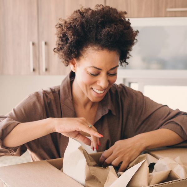 Image show a person smiling looking in a cardboard box