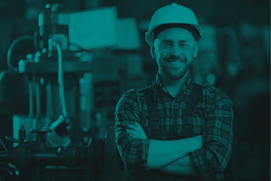 Image of a person in a hard hat standing in front of machinery